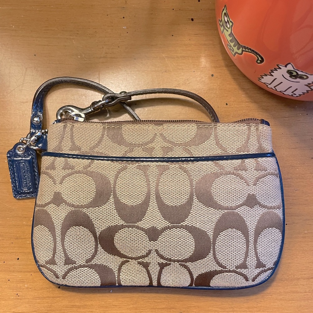Coach signature C wristlet with navy blue trim and coach mini tag. EUC.
